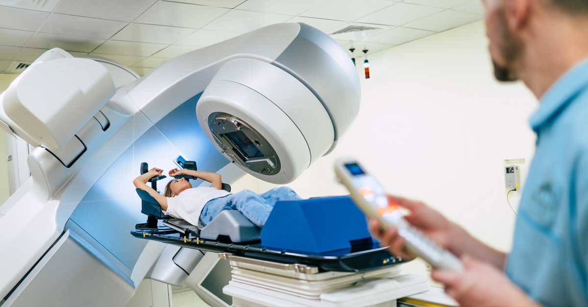 Cancer treatment with a linear accelerator. Radiation oncologist working while the woman is undergoing radiation therapy for cancer.